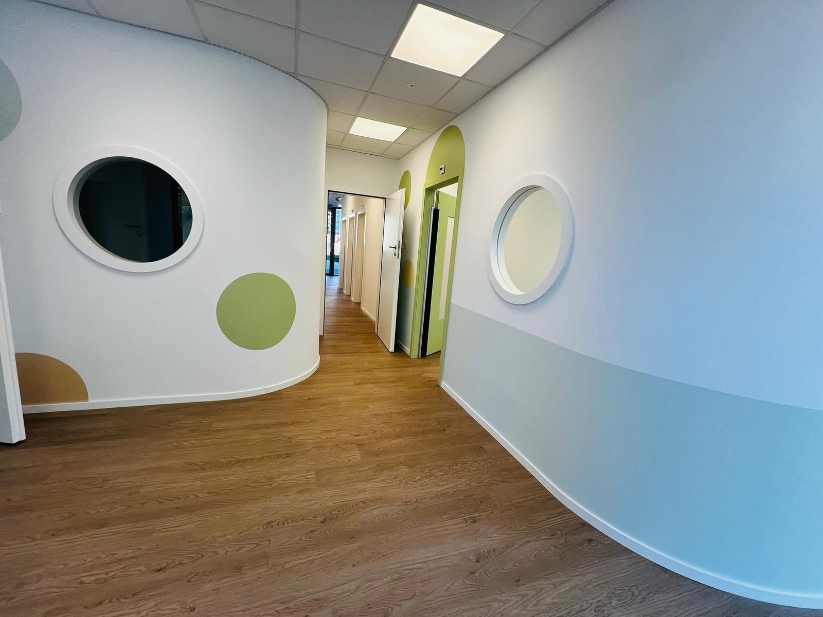 Couloir intérieur rénové avec cloisons colorées et hublots ronds – Entreprise du Bâtiment MS SA