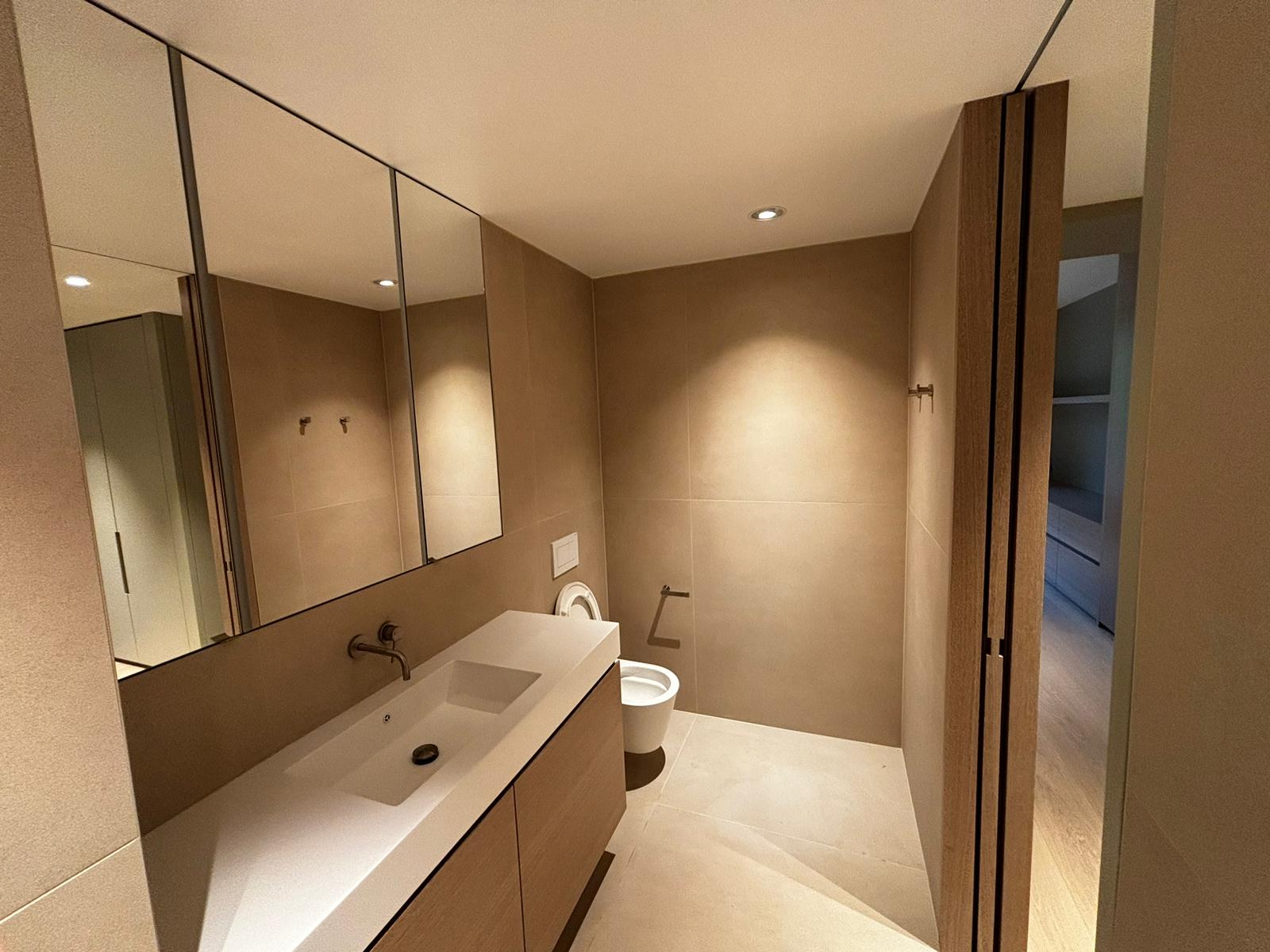 Salle de bain rénovée avec double vasque et douche vitrée à Genève – Entreprise du Bâtiment MS SA