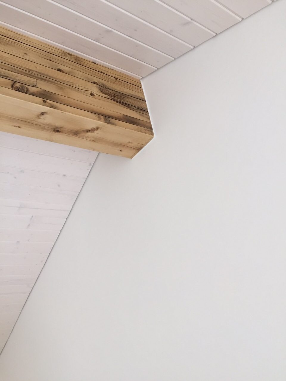 Poutre en bois apparente et lambris blanchi