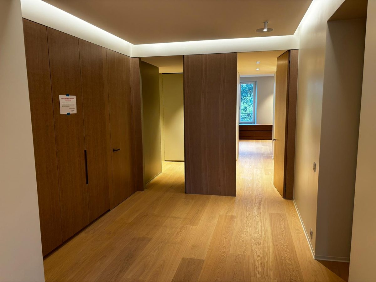 Couloir habillé de bois avec parquet et éclairage indirect