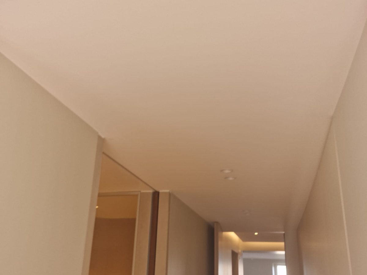Couloir aux murs et au plafond peints en beige