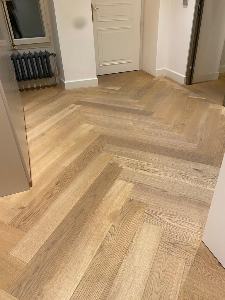 Parquet en chevrons en chêne clair posé dans un couloir à Genève