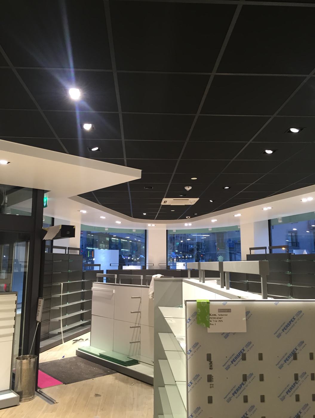 Espace de vente d'une pharmacie à Genève en fin d'aménagement, plafond acoustique noir