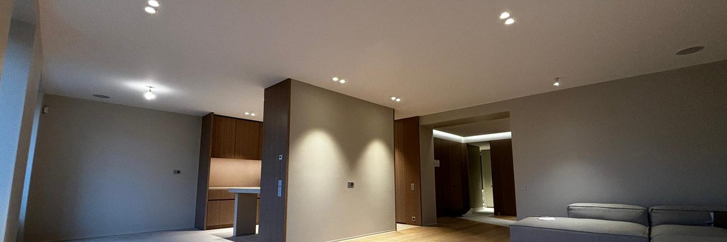 Séjour rénové d'un appartement à Genève, parquet et éclairage intégré