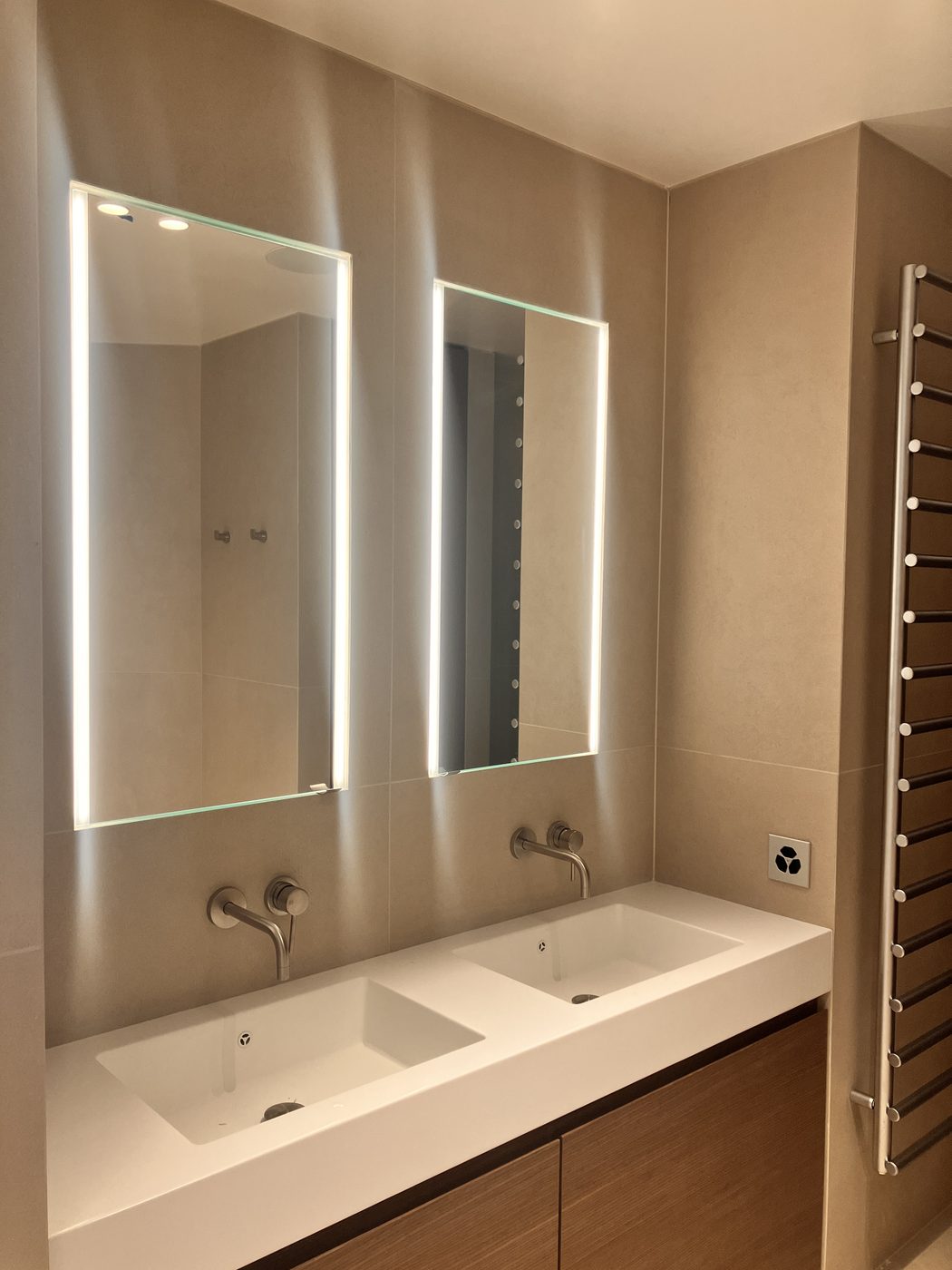 Salle de bains rénovée à Genève : double vasque et miroirs lumineux