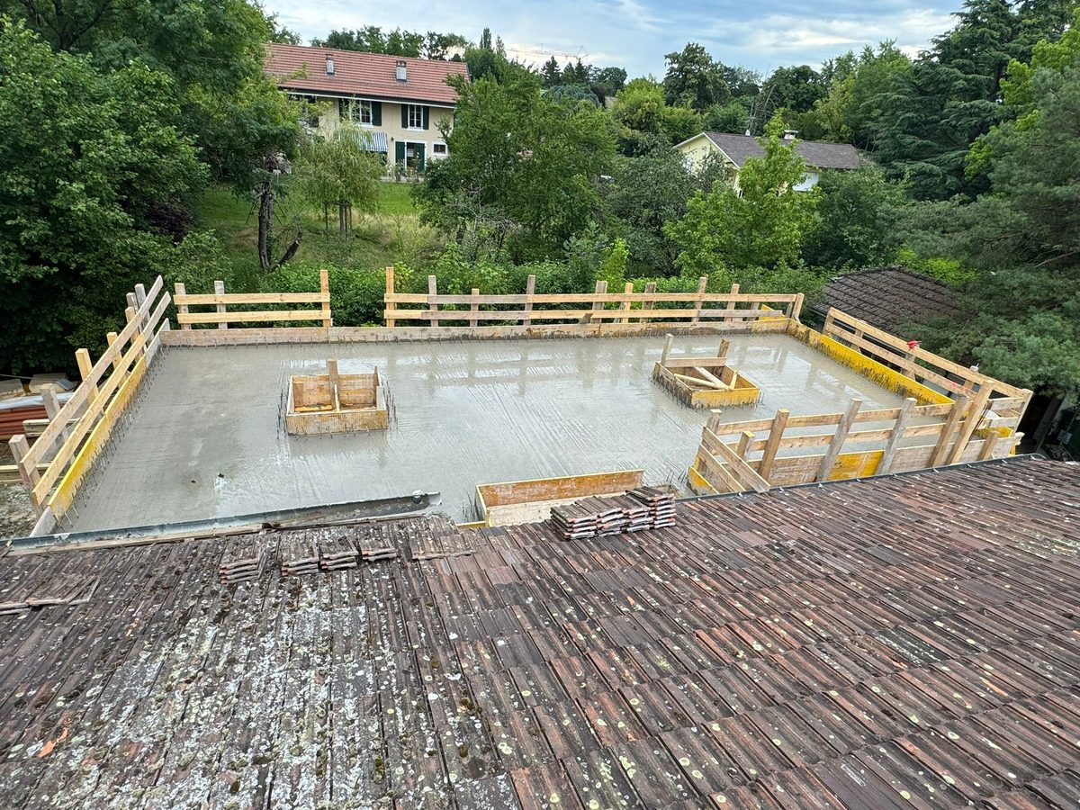 Dalle de béton coulée et coffrage bois sur un terrain en pente